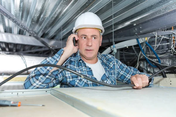 Appaltatore nello spazio del tetto, parlando al telefono — Foto Stock