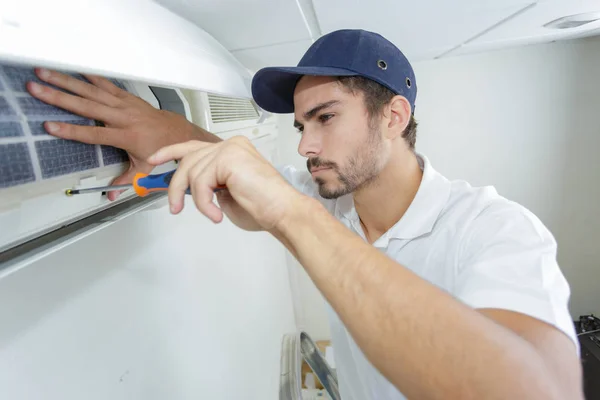 Porträtt av mitten av vuxna manliga tekniker reparera luftkonditioneringen — Stockfoto