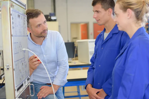 Studenten kijken naar kabel aan boord — Stockfoto