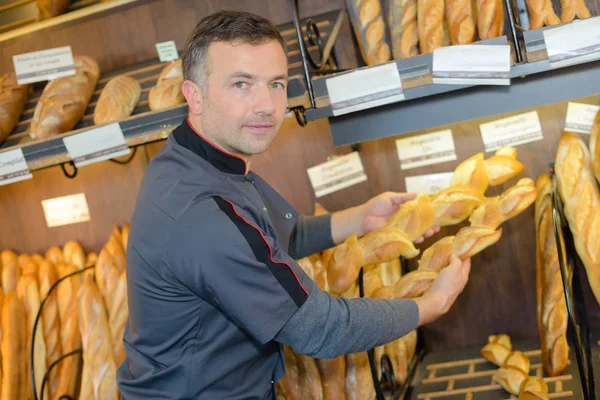 Padeiro segurando baguetes e padeiro — Fotografia de Stock