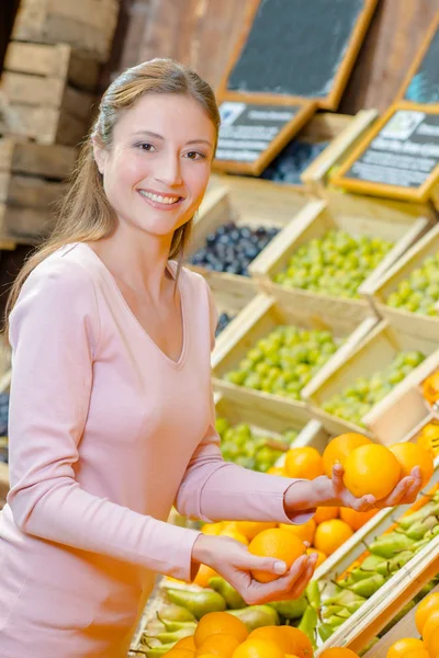 Дама вибирає апельсини в продуктових магазинах — стокове фото