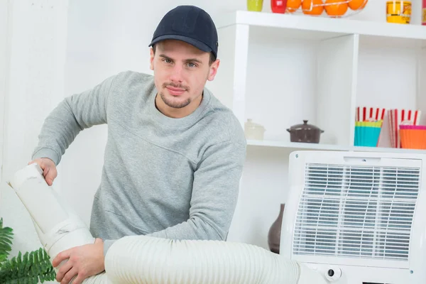 Handsome technician installing air-conditioner in building — Stock Photo, Image