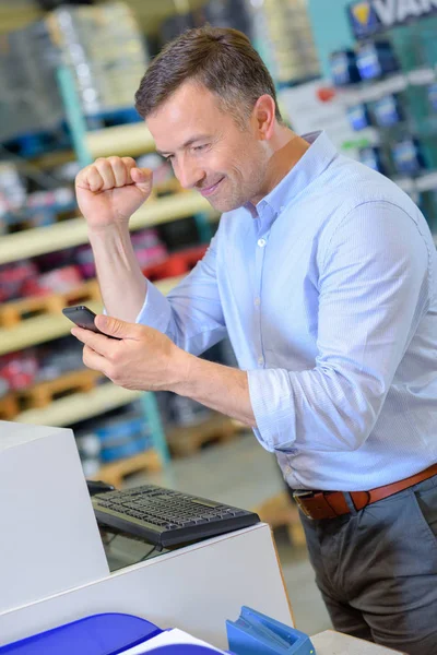 Uomo guardando il telefono cellulare facendo gesto di successo — Foto Stock