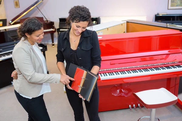 Mujeres comparando muestras de color para un piano —  Fotos de Stock