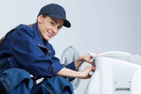 Mujer trabajando en la unidad de aire acondicionado — Foto de Stock