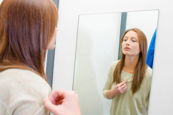 Frau sieht sich selbst im Spiegel an — Stockfoto