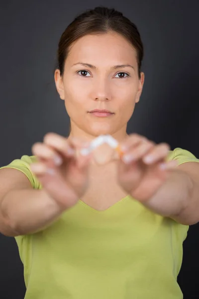 Woman breaking cigarette in two — Stock Photo, Image