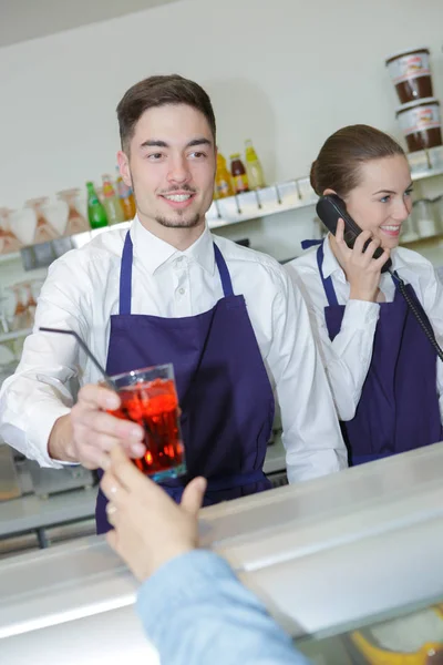 Kellner serviert Getränke und Geschirr — Stockfoto