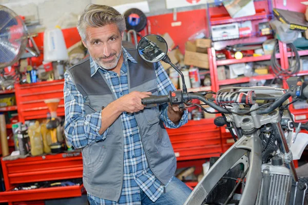 Arbeiter repariert ein Motorrad — Stockfoto