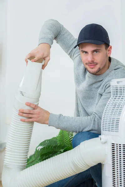Ung tekniker installera luftkonditioneringssystem inomhus — Stockfoto