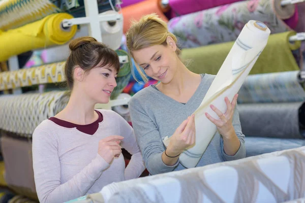 Donne che guardano rotolo di materiale — Foto Stock