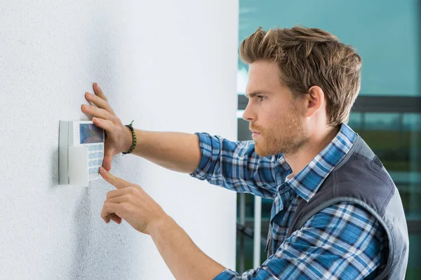 Knappe jonge elektricien herstel intercom — Stockfoto