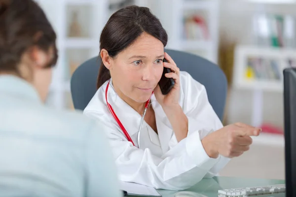 Medico con paziente che parla al telefono e mostra risultati — Foto Stock
