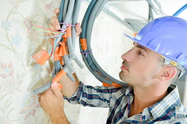 Builder holding cables together with tape & ties — Stock Photo, Image