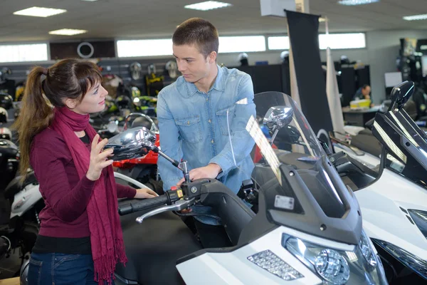 Man and woman in vehicle showroom — Stock Photo, Image