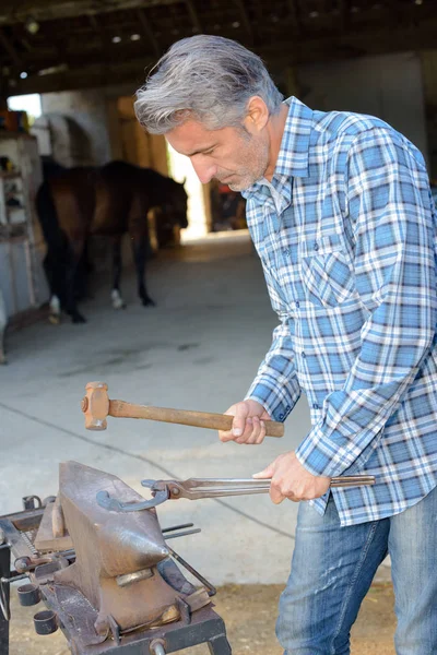 Farrier usando martelo na bigorna — Fotografia de Stock