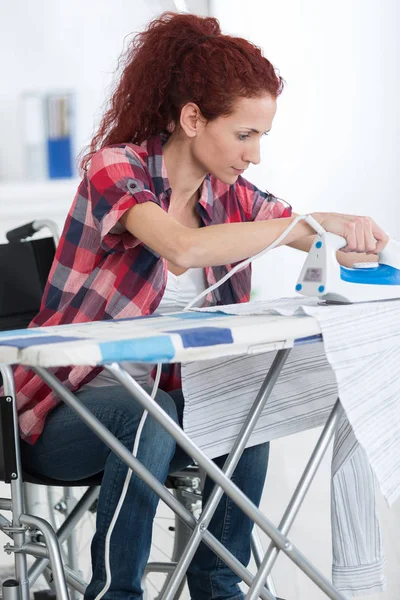 Behinderte Frau beim Bügeln zu Hause — Stockfoto