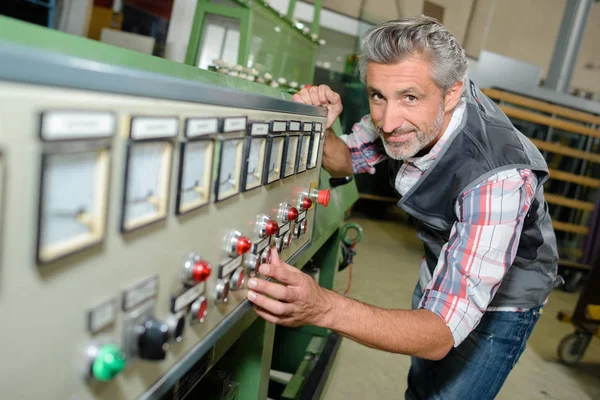 Worker adjusting the machine — Stock Photo, Image