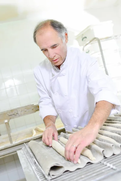 Hombre preparando baguettes y adulto —  Fotos de Stock