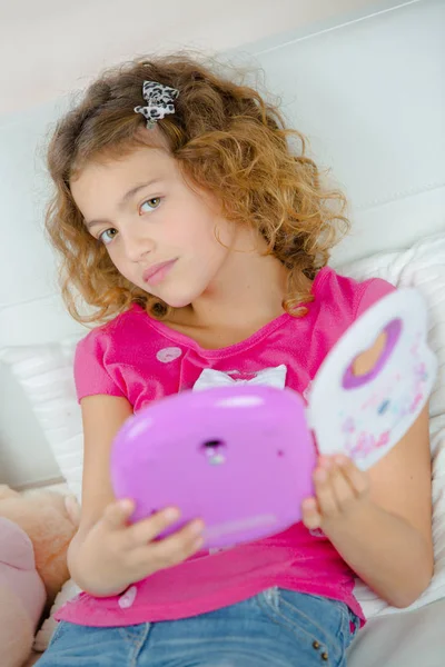 Маленькая девочка держит игрушечное электрическое устройство — стоковое фото
