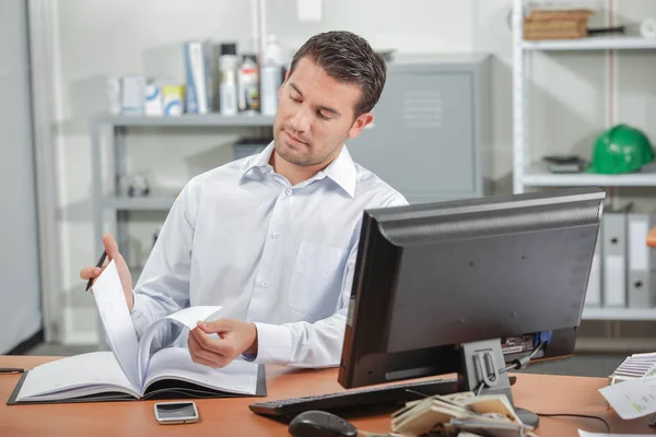 Büroangestellte liest am Schreibtisch — Stockfoto