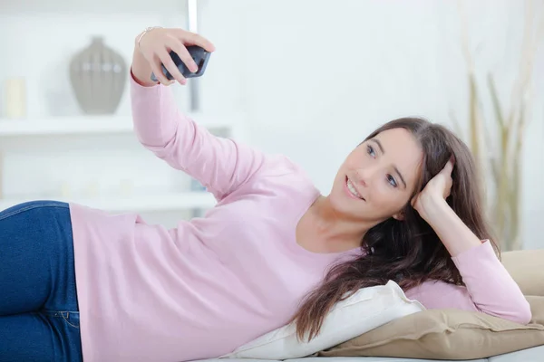 Lady layed on her side taking photograph of herself — Stock Photo, Image