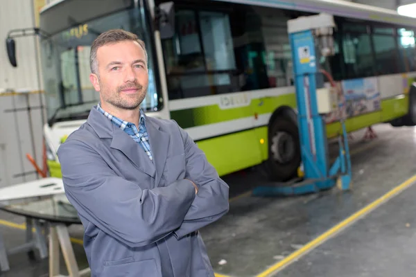 Ônibus mecânico posando e homem — Fotografia de Stock