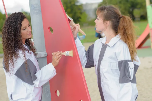 Twee vrouwen schilderij park apparatuur — Stockfoto
