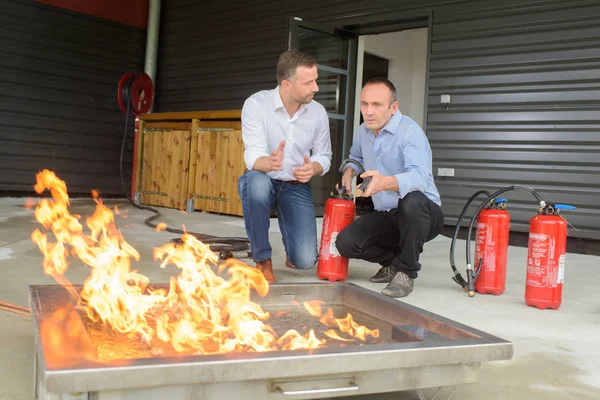 Men training with fire extinguishers — Stock Photo, Image