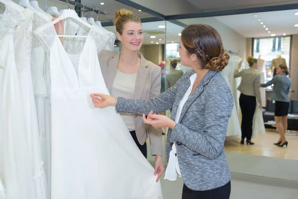 Vrouw kijken naar trouwjurken — Stockfoto