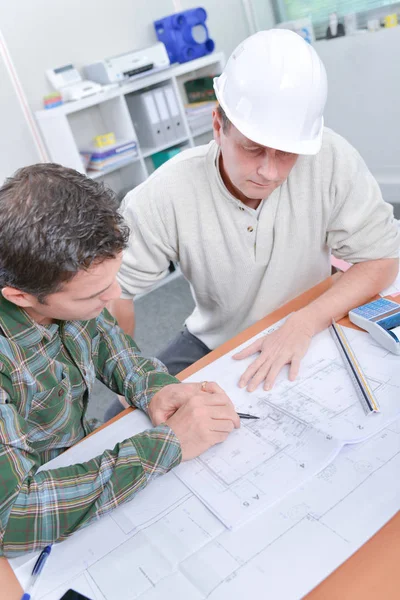 Twee mannen zat bij balie kijken blauwdrukken — Stockfoto