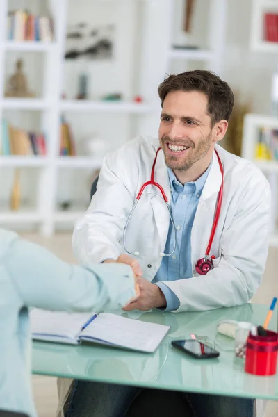 Jovem médico bonito no trabalho em seu escritório — Fotografia de Stock