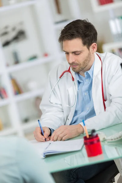 Ιατρική γιατρός γιατρός ακούει στον ασθενή και λήψη σημειώσεων — Φωτογραφία Αρχείου