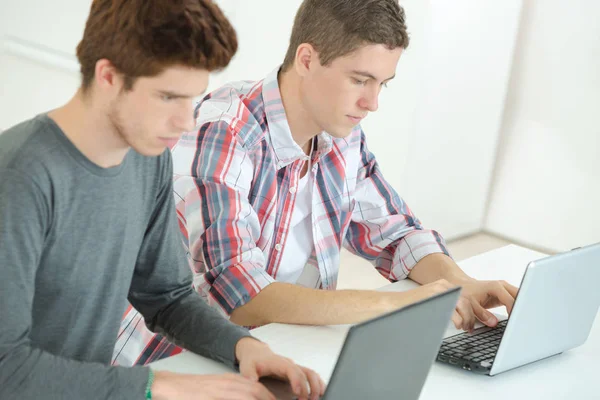 Dois estudantes do sexo masculino usando laptops — Fotografia de Stock