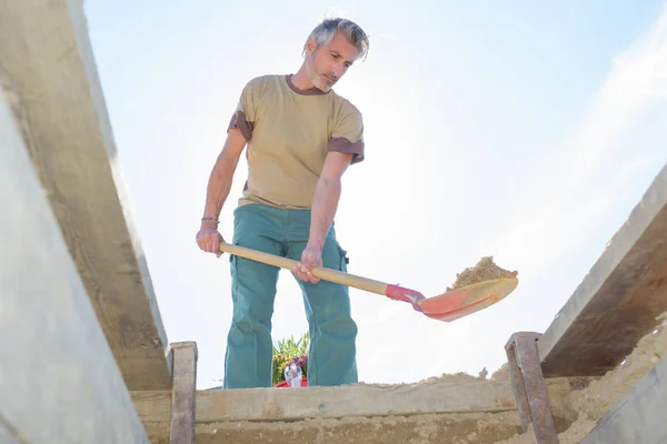 Homem usando uma pá para cavar — Fotografia de Stock