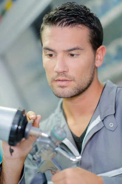 Mechanic holding components of spray gun — Stock Photo, Image