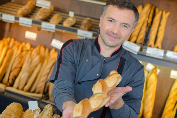 Padeiro mostrando baguete e padeiro — Fotografia de Stock