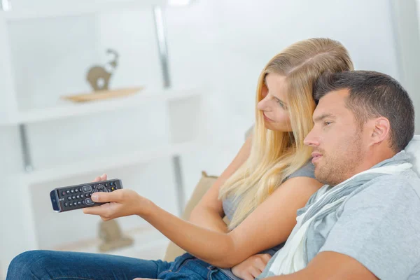 Casal brincalhão brigando pelo controle remoto da TV — Fotografia de Stock