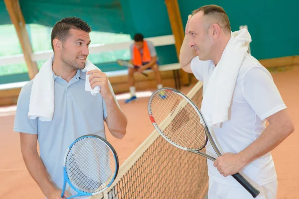 Män som chattar på tennisbana — Stockfoto