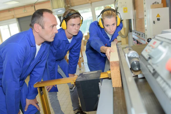 Vrouwelijke leerling timmerman met behulp van machines — Stockfoto