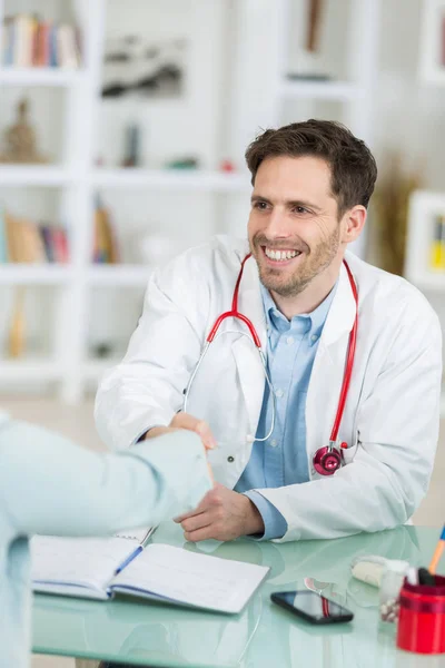 Knappe jonge dokter op het werk in zijn kantoor — Stockfoto