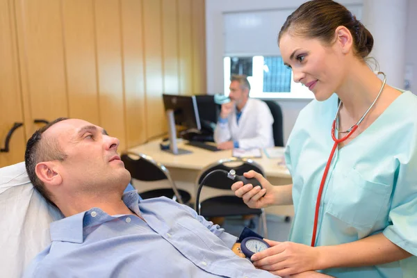 Krankenschwester nimmt dem Mann den Blutdruck — Stockfoto