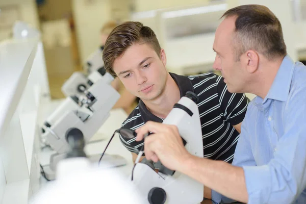 Teacher and student looking at lens Stock Picture