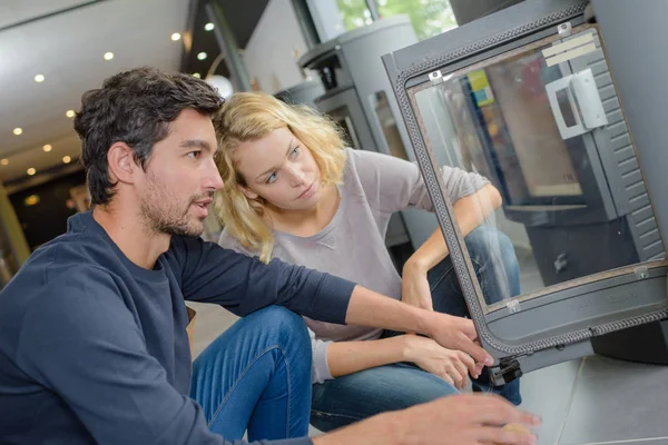 Couple looking at a woodburner in a store — Stock Photo, Image