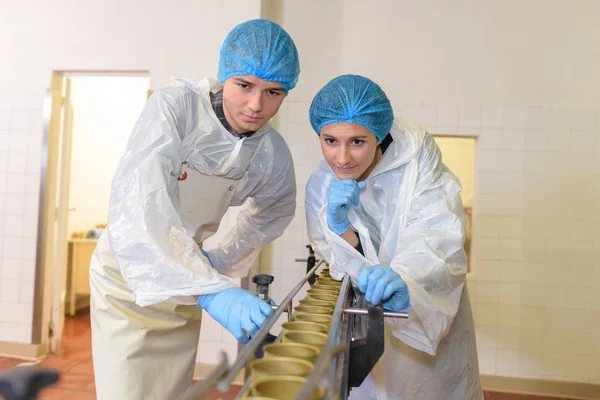 Agentes assistindo contêineres descem transportador de fábrica — Fotografia de Stock