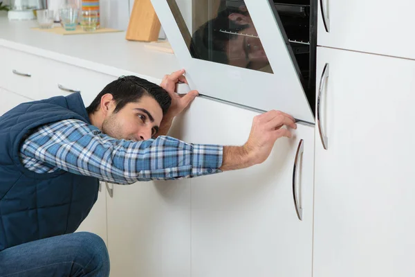 Man fitting new oven