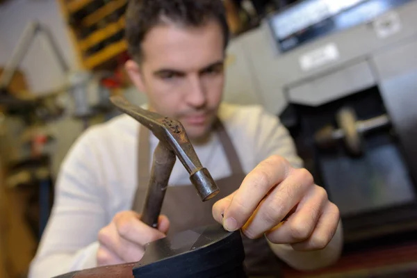 Cobbler hammering nail into heel of shoe — Stock Photo, Image