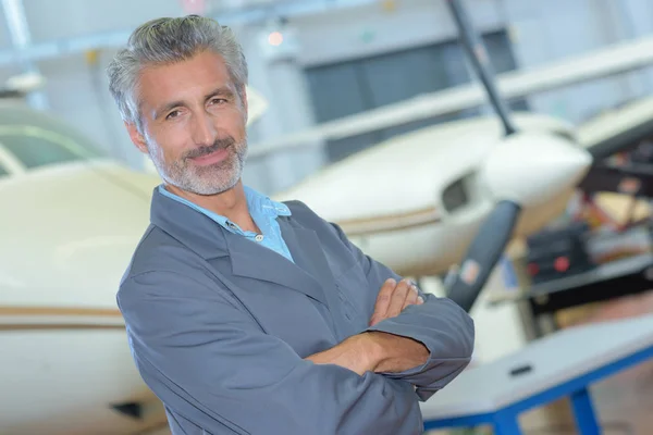Porträt eines Mannes mittleren Alters im Flugzeughangar — Stockfoto
