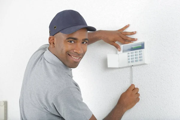 Retrato de homem fixando teclado na parede — Fotografia de Stock