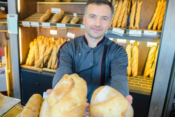 빵집 주인이 그의 빵 생산의 자랑은 — 스톡 사진